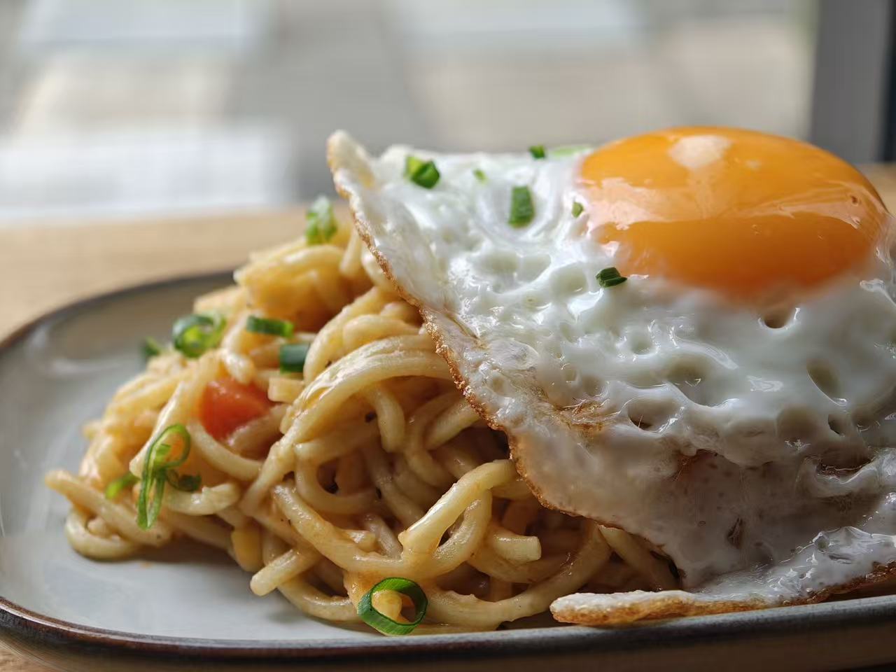 Tôvola mushroom teppanyaki noodles topped with a fried egg
