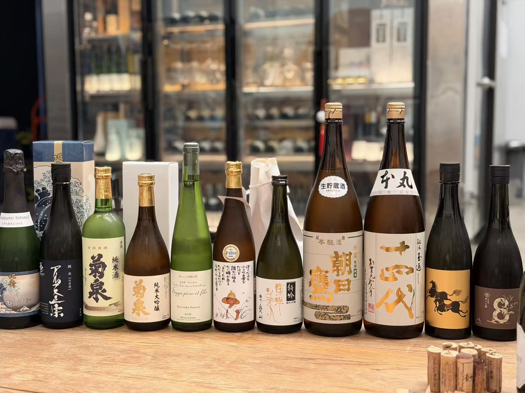 A real photograph of SakeMeta’s bottles arranged side by side on a wooden table